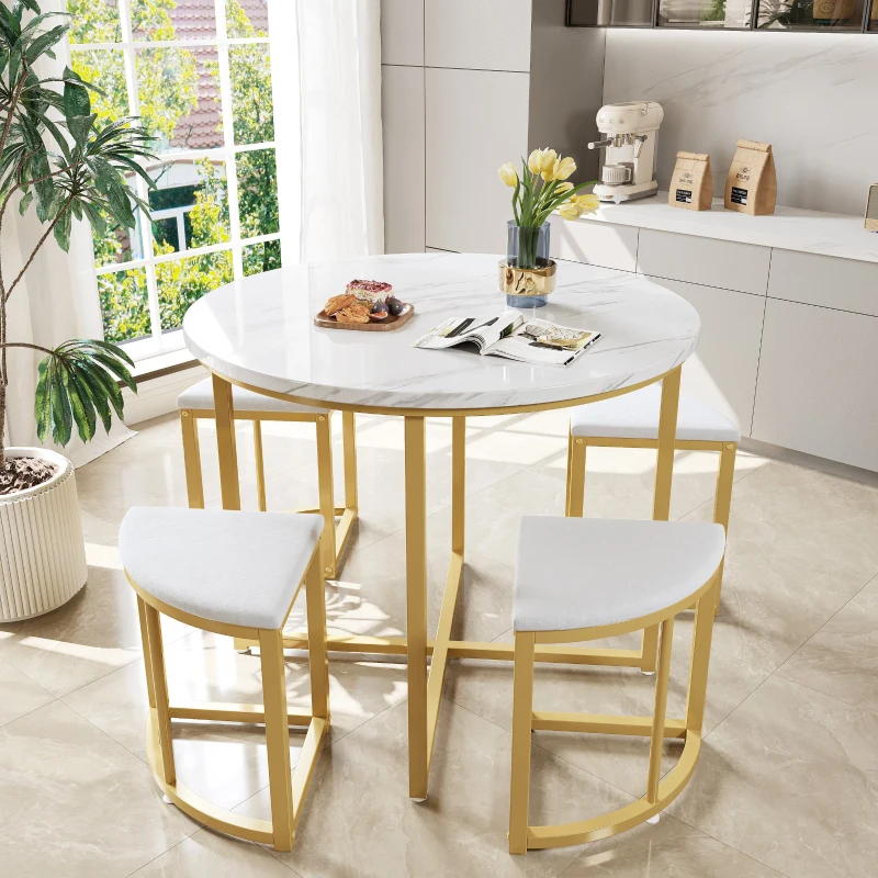 Elegant round marble dining table with gold legs and stools in bright modern kitchen.
