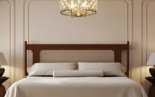 Elegant bedroom with crystal chandelier above neatly made bed.