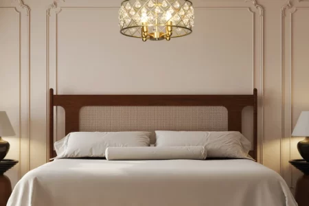 Elegant bedroom with crystal chandelier above neatly made bed.