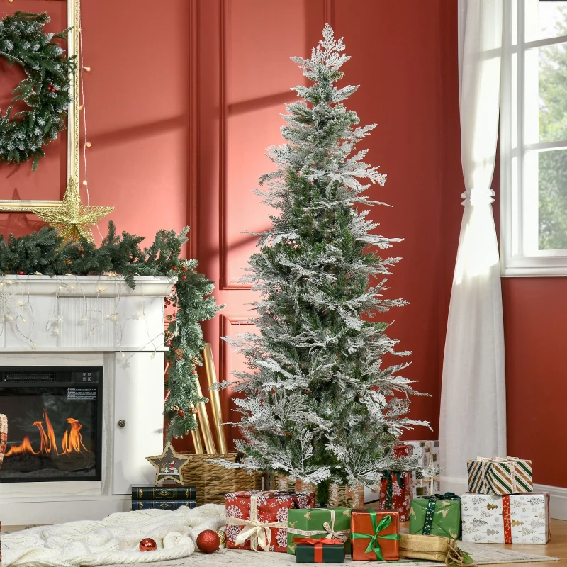 Artificial Christmas tree beside fireplace with red wall and wrapped presents under it.
