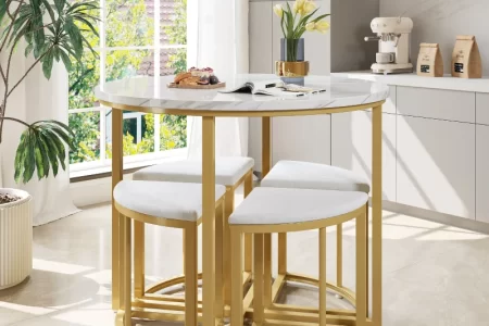 Modern white dining area with light wood table, four chairs, and indoor plants.