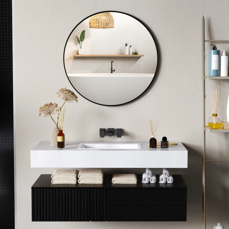 Round bathroom mirror above modern vanity with black cabinet