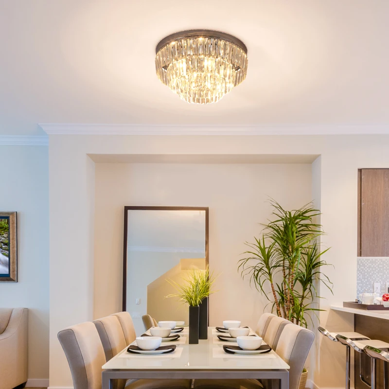 Stylish dining room with round crystal chandelier above table.