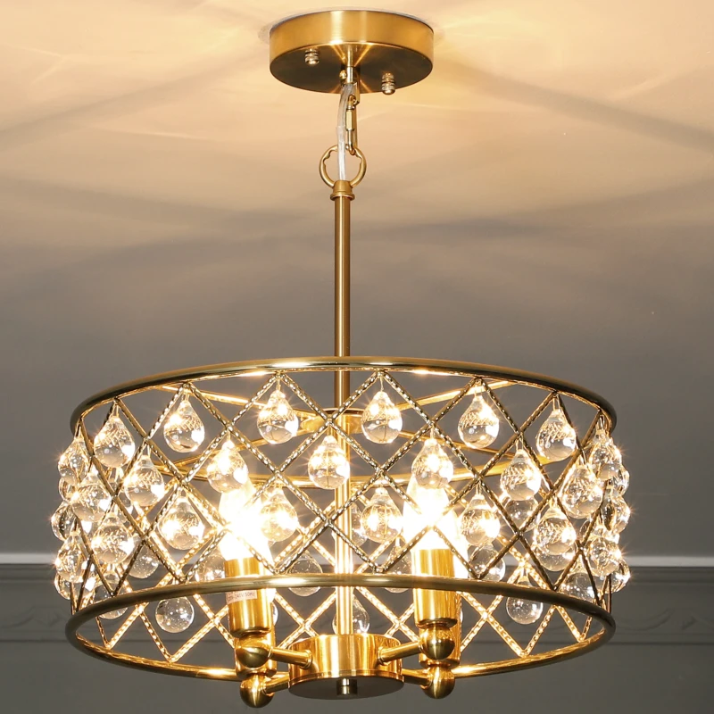 Close-up of gold chandelier with crystal droplets glowing warmly.