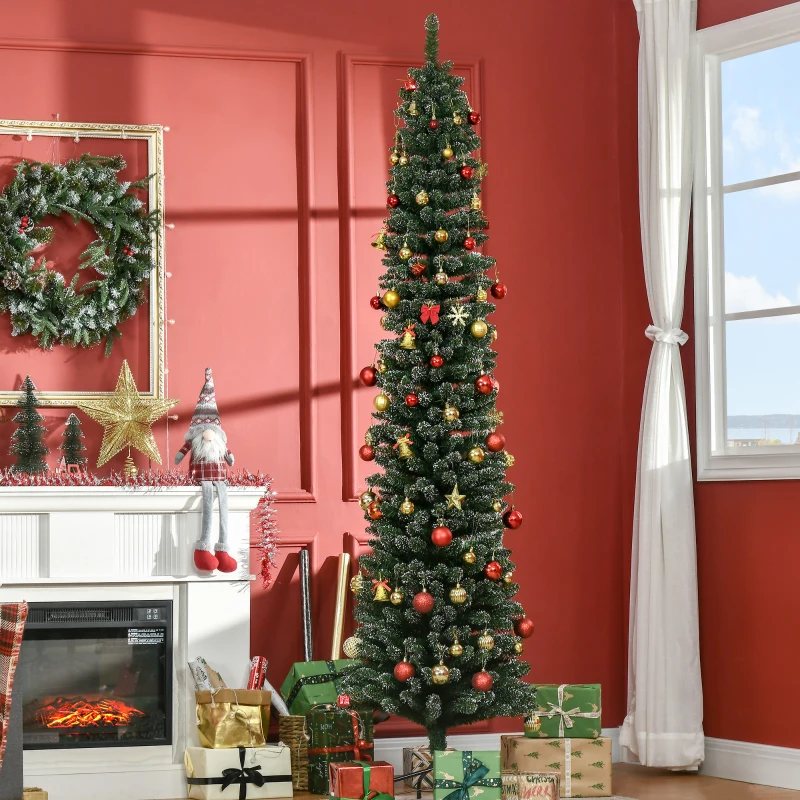 Tall pencil Christmas tree with red and gold ornaments set by fireplace with presents.

