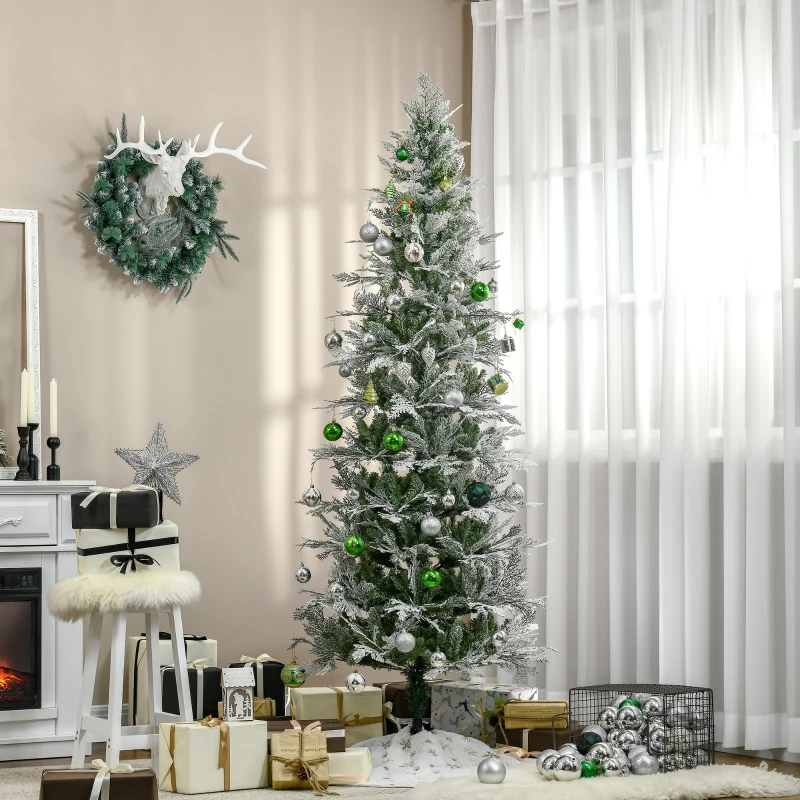 Tall slim Christmas tree with green and silver baubles beside gifts and white fireplace.
