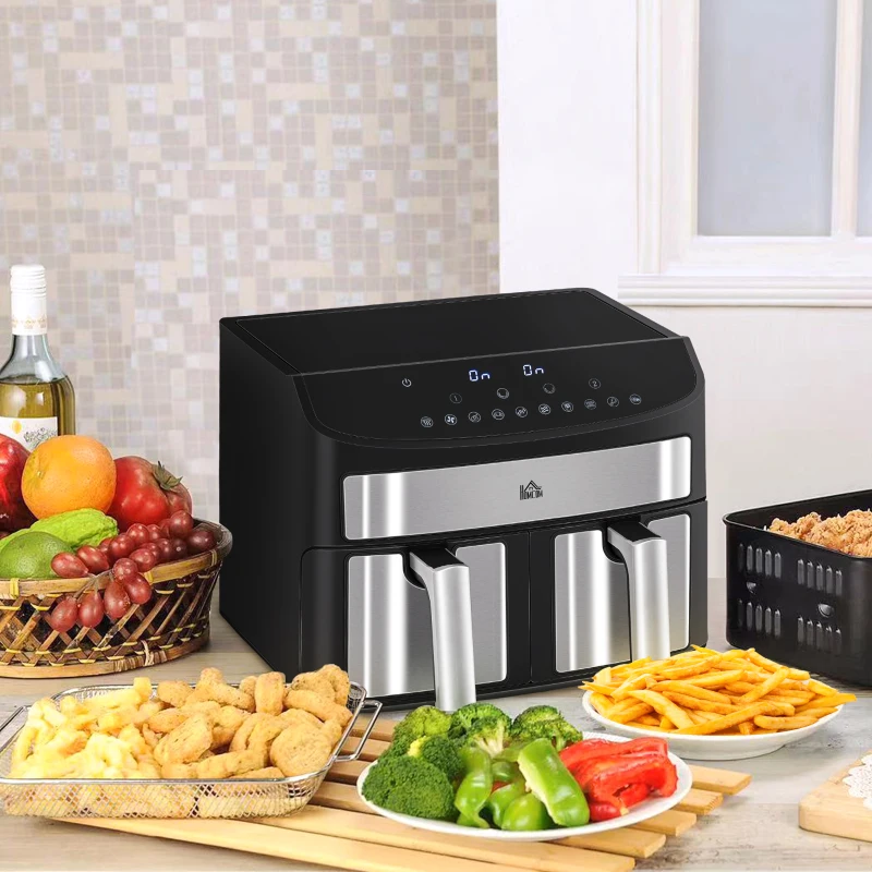 Dual zone stainless steel air fryer on counter with fries, vegetables, and fried chicken.
