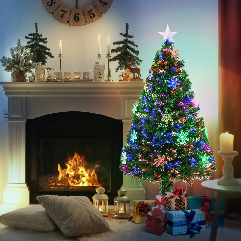 Colorful fibre optic Christmas tree beside lit fireplace.