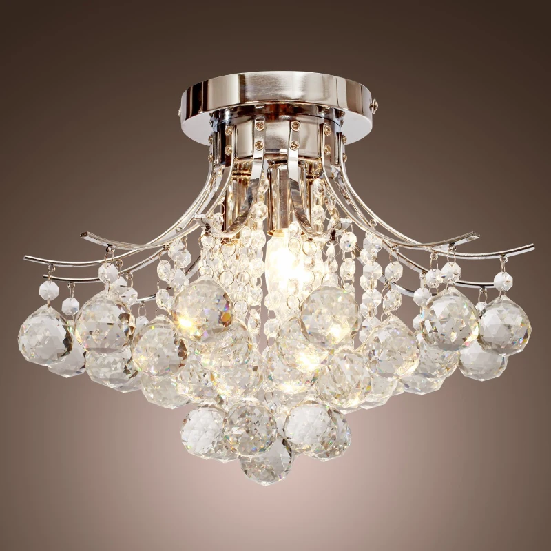 Silver crystal chandelier with round droplets hanging from ceiling.