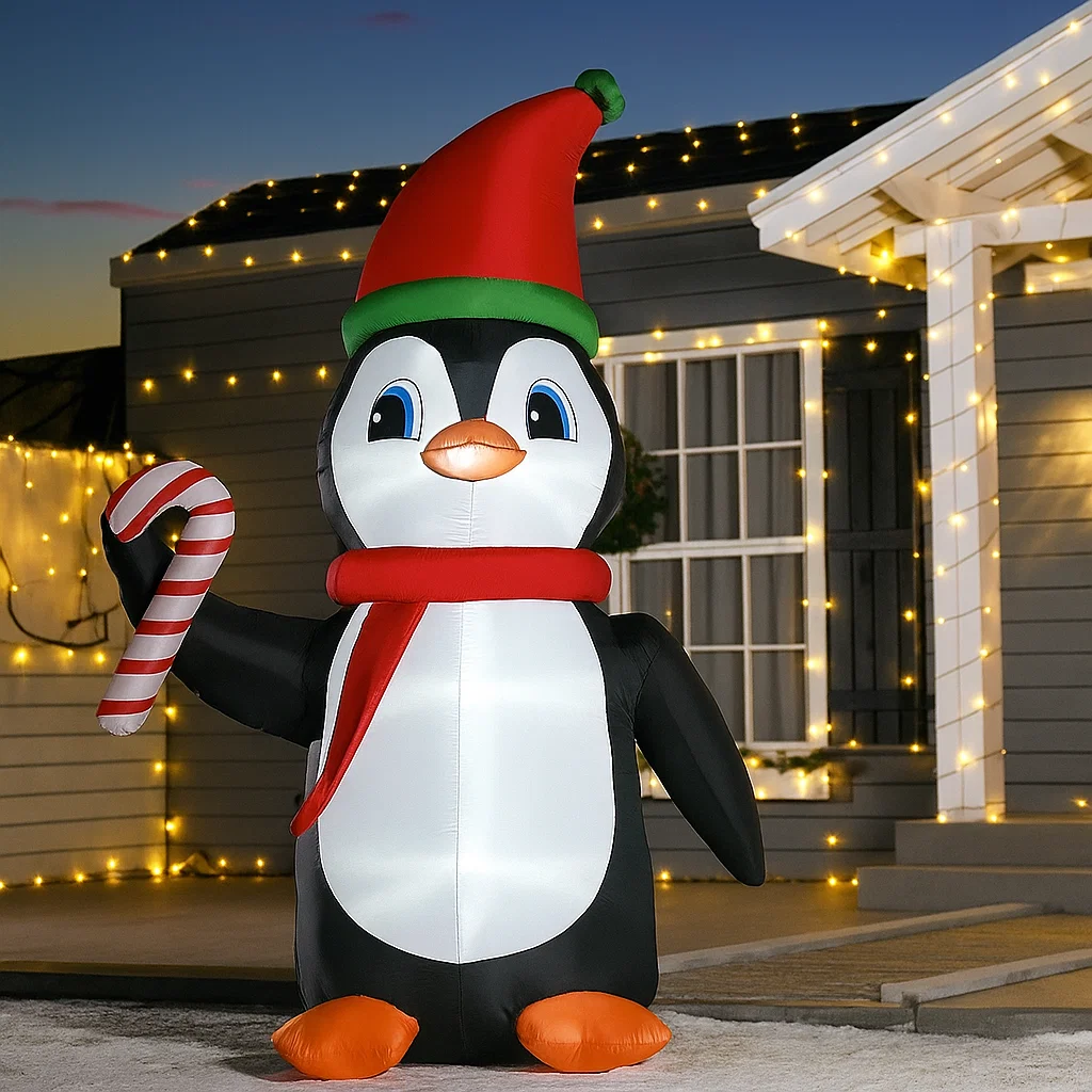 Inflatable penguin with candy cane and Santa hat outdoors