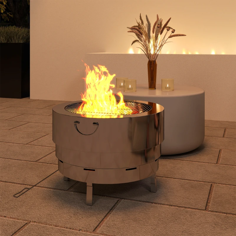 Stainless-steel wood-burning fire pit glowing on modern patio.

