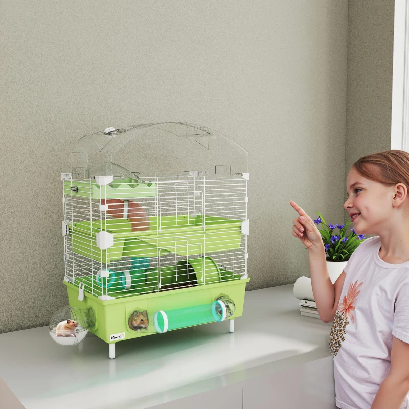 girl pointing at green multi-level hamster habitat
