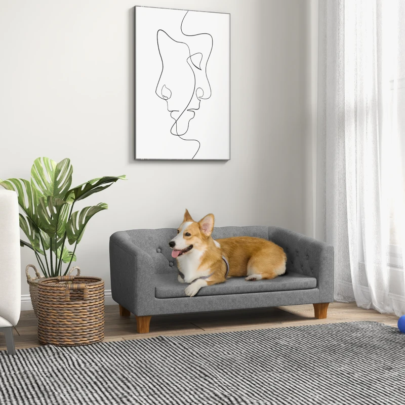 Corgi relaxing on soft grey sofa with modern wall art.