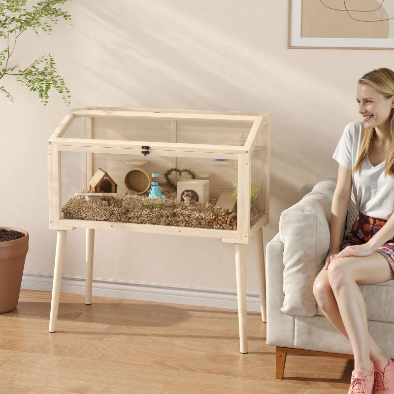 Modern light wood hamster cage on legs with accessories, woman sitting.

