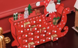 Red wooden advent calendar with Santa and tiny drawers.