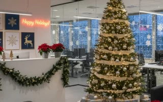 Office lobby Christmas tree with gifts and festive garlands.