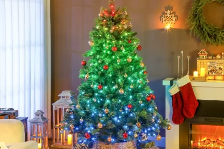 Christmas tree glowing with multicolour lights in living room.