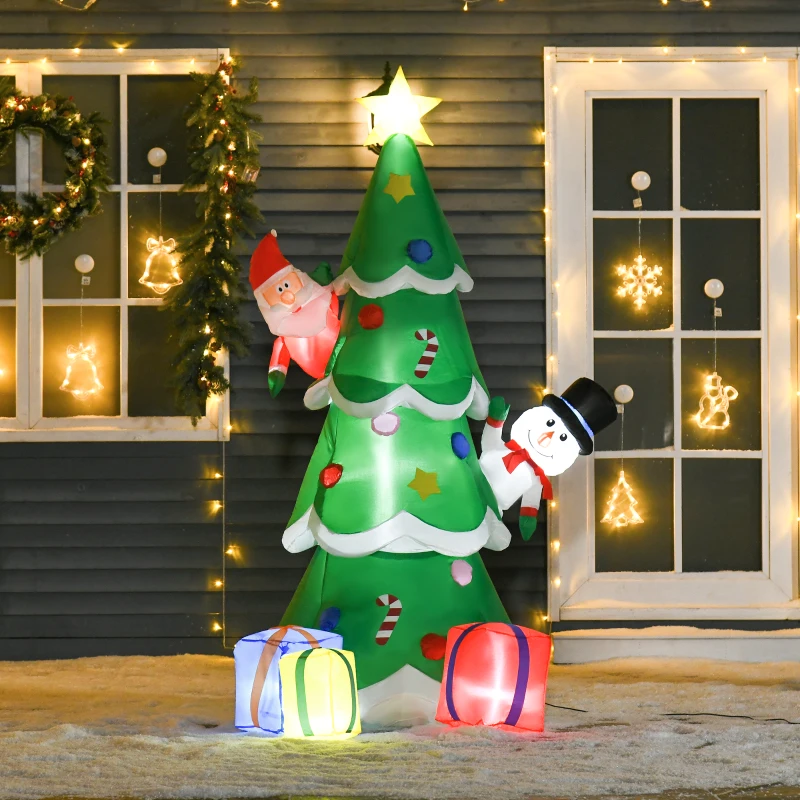 Inflatable Christmas tree with Santa and snowman outdoors.